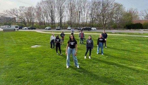 students posing outside on grass