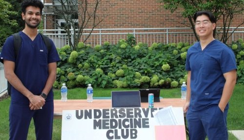 Underserved Medicine Club members pose with poster.