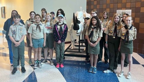 Boy Scouts of America troop stands in front of Rhino skeleton at the Animal Health Institute.