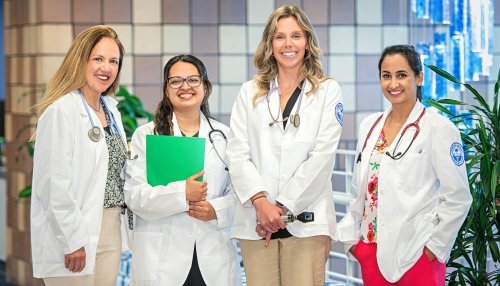 Four nursing faculty members in white coats.