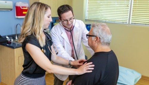 Doctors examine male patient.