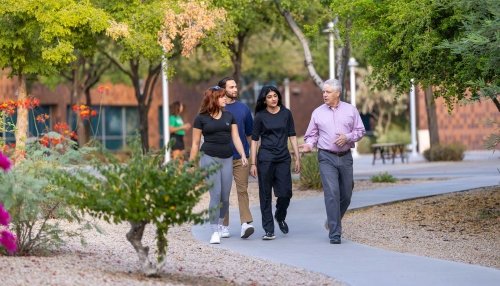 Three students wanting with a professor discussing fall prevention and public health.