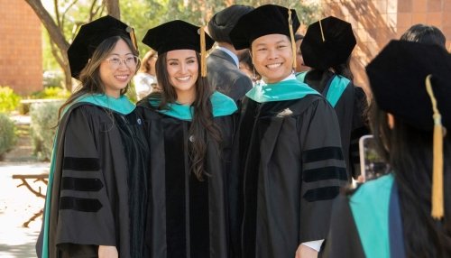 Graduates outside posing for camera