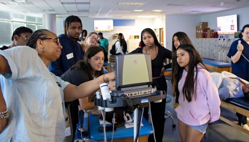 Students and faculty look at ultrasound maching