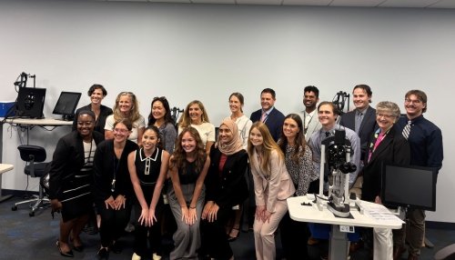 Group of students and vistors pose for photo