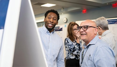 A student explains his research poster 