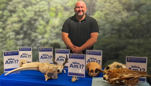 Kevin Manfredi stands by a collection of animal skulls displayed at the Arizona Museum of Natural History