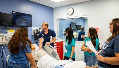 A Midwestern student shows undergrad mentees clinical skills in the SIM center