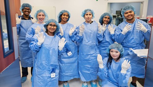 Participants learn to correctly gown and glove for surgery in the mock operating room.