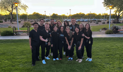 group photo of students outside wearing scrubs