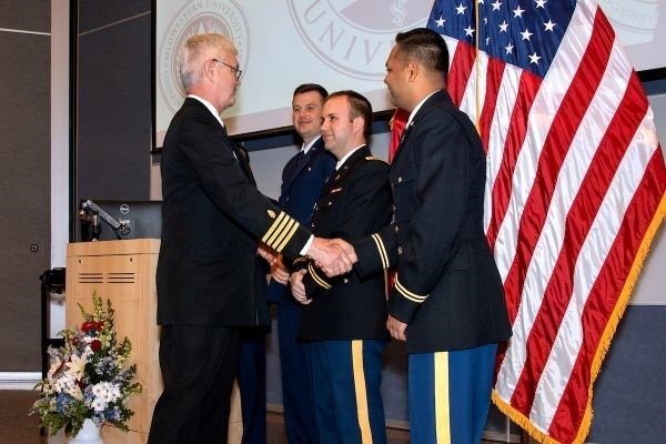 Dr. Williams congratulates students in the Military Commissioning Ceremony