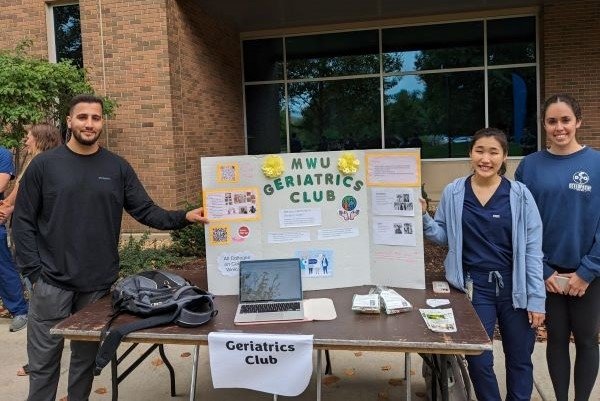 Geriatrics club members take a picture with their club poster.