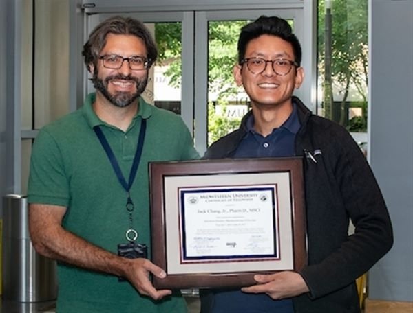 Dr. Chang holds his residency completion certificate with Dr. Scheetz.
