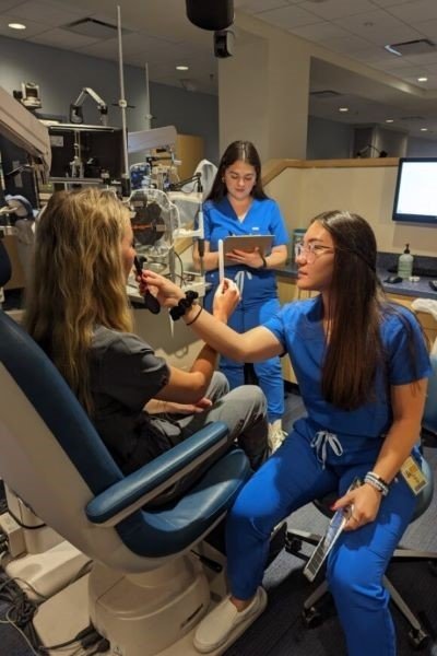 Optometry students check the vision of dental students.