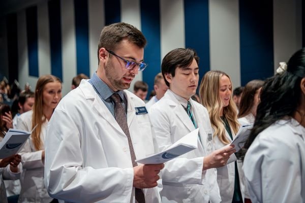 Students receive their white coats.