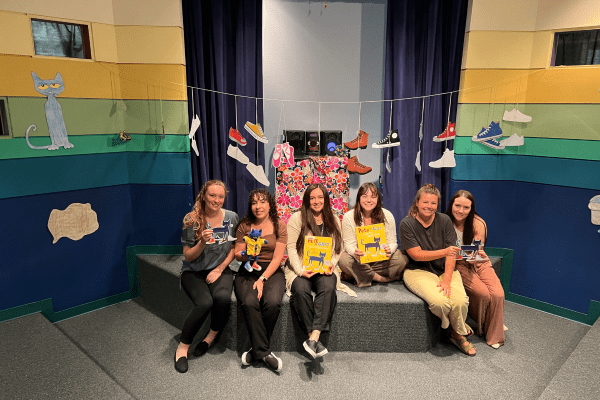 SLP students during the Family Literacy night carrying visual aids to help children read.