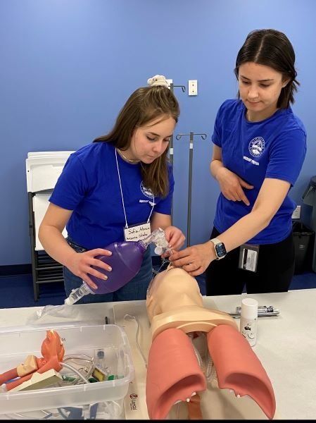 Midwestern student assists student with a lab activity. 