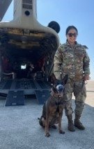 Denise Sorbet stands next to a working military dog.