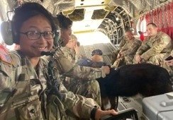 Denise Sorbet and team members sit in the hold of plane with a working military dog.