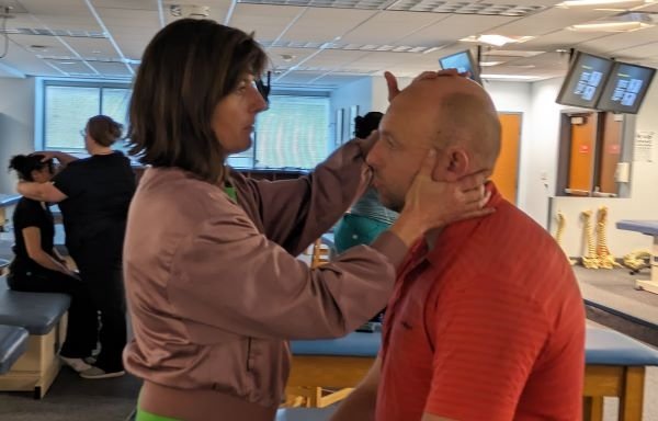 The visiting osteopaths practice the techniques they were shown.