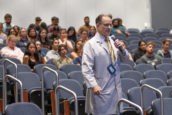 Dr. Borelli speaks in an auditorium full of medical students.