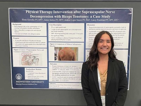 Elena Gawelko, dressed formally, standing in front of her presentation.