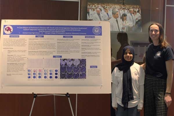 Claire Manhard and Areej Binmahfooz pose with their poster presentation.