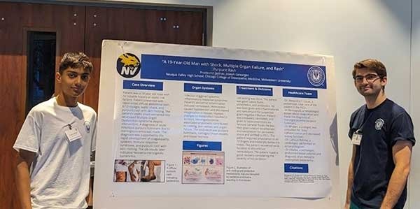 Joseph Gewarges and Prad Jadhav pose with their poster presentation.