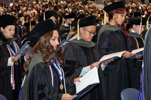 Pharmacy graduates examine their programs.