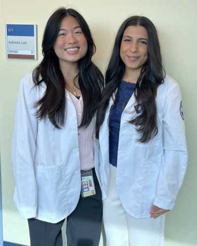 Lauren Aniceto and Saya Albonaimi in their white coats.