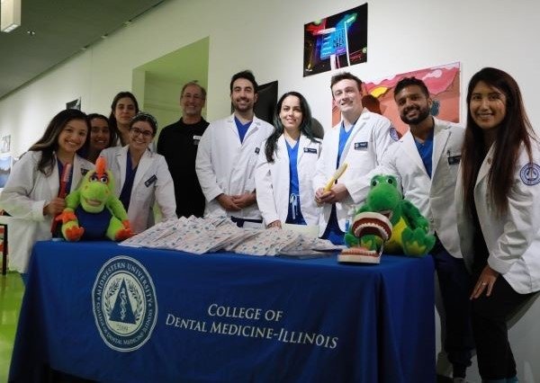 CDMI ASDA members gather for a photo during their community outreach in white coats.