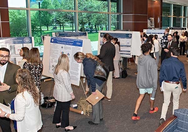 Midwestern University students present their research posters at Cardinal Hall.