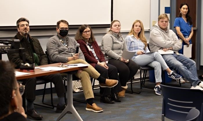 A panel, seated in a line, of faculty, staff and students give networking advice to first-generation students. 