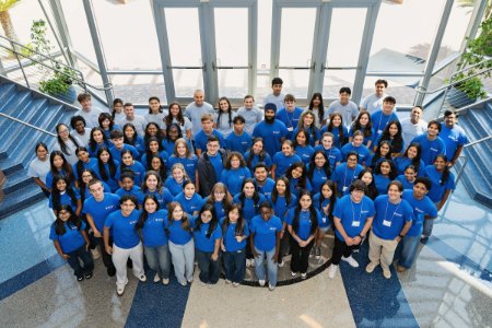64 high school students and 16 Midwestern student mentors smile in their matching HCI t-shirts