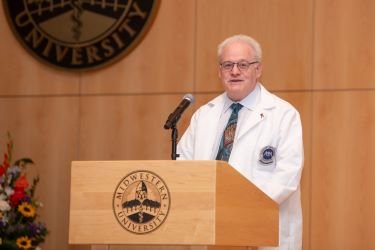 Dr. Wolf stands at podium